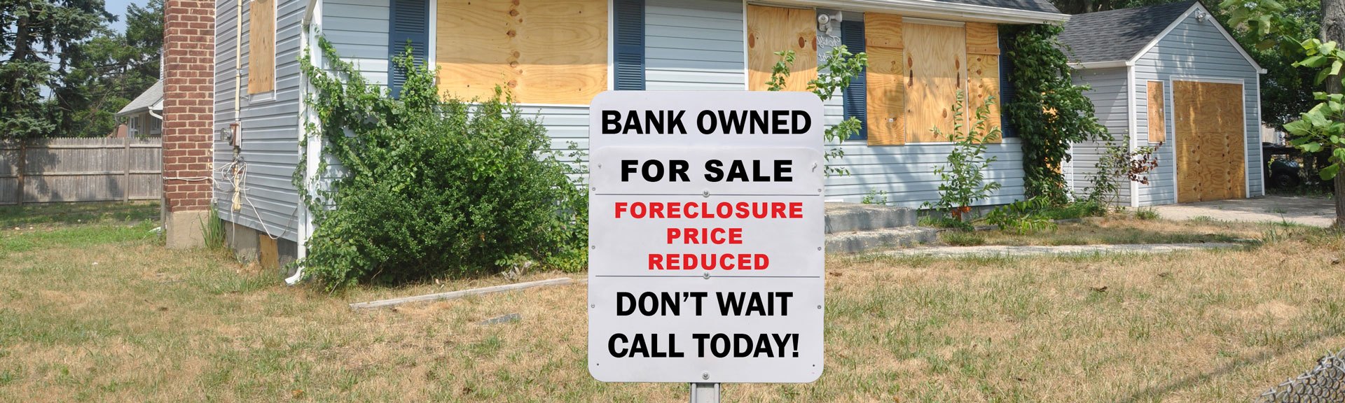House with a foreclosure sign in the yard